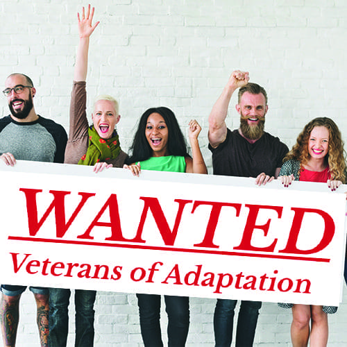 Five people celebrating behind a "WANTED Veterans of Adaptation" sign
