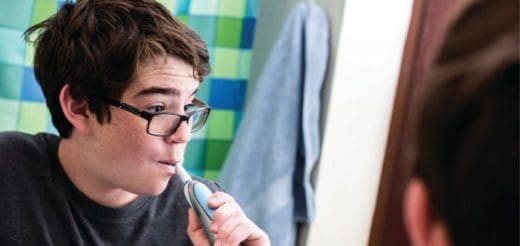 Teenager brushing teeth in the bathroom