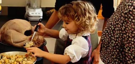 A young girl helps prepare a Thanksgiving turkey.
