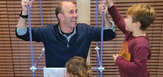 Greg Santucci demonstrates an occupational therapy activity with two children.
