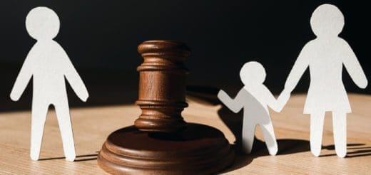 Paper figures of parents and child with a gavel suggest a divorce case.