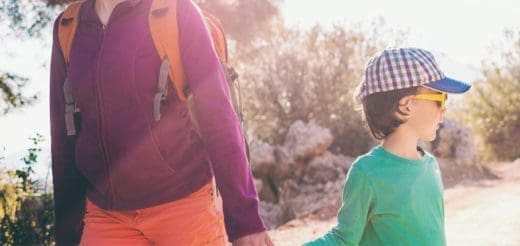 Two people with backpacks walking on a trail