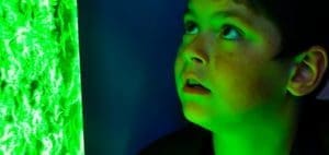 Boy looking at a green light display