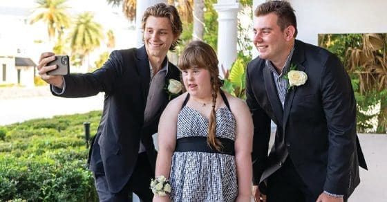 Two young men and a girl pose for a selfie.