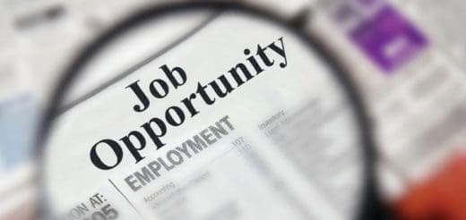 Magnifying glass over a newspaper section labeled "Job Opportunity Employment.