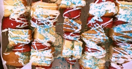 Patriotic-themed dessert skewers with white icing and blue sprinkles.