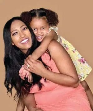 Indigo Abell with her daughter piggyback riding.
