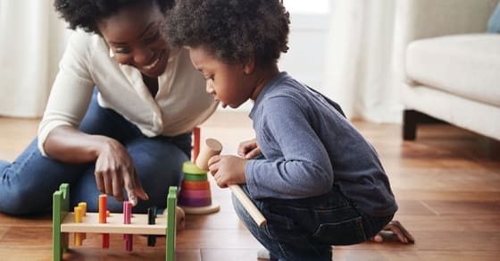 Woman and child playing with a toy.