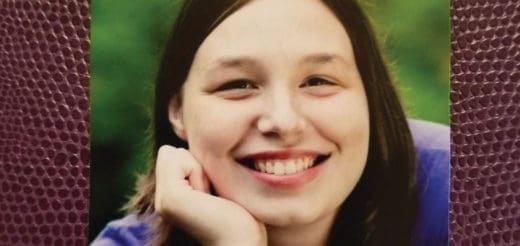 Young woman smiling with her hand on her chin