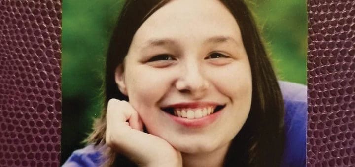 Young woman smiling with her hand on her chin