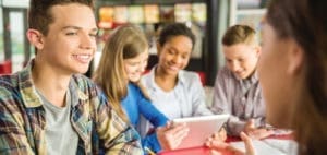 Students gathered around a tablet during a conversation.