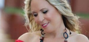 Lisa Lupi smiling with blonde hair and a necklace.
