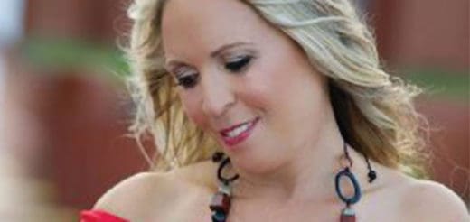 Lisa Lupi smiling with blonde hair and a necklace.