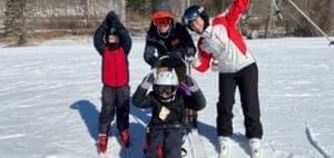 Four skiers in ski gear on a snowy slope.