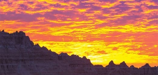 Sunrise over the Badlands National Park with dramatic clouds.