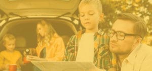 Family with a map in front of an open car trunk