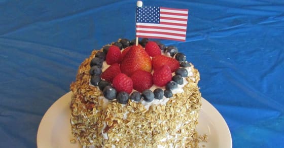 Cake topped with berries and a small American flag.