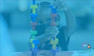 Child building a colorful toy tower.