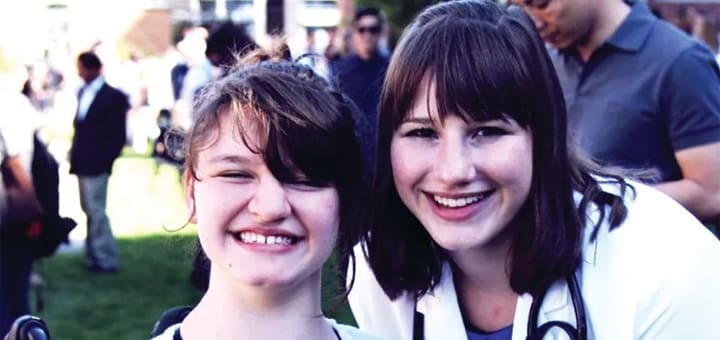 Dr Deanna Clauss and her sibling smile at the camera