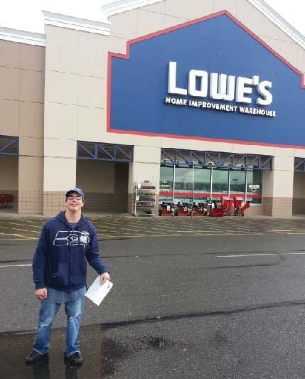 Man standing in front of a Lowe's store.
