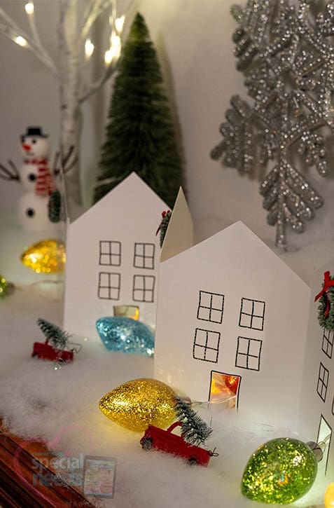 Paper chain houses and Christmas decorations creating a winter village scene.