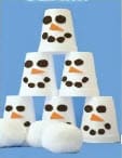 White cups stacked and decorated to look like snowmen faces.