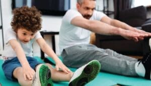 Man and child stretching on yoga mats
