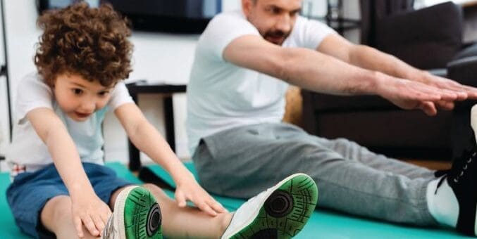 Man and child stretching on yoga mats