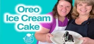 Two women present a slice of Oreo ice cream cake.