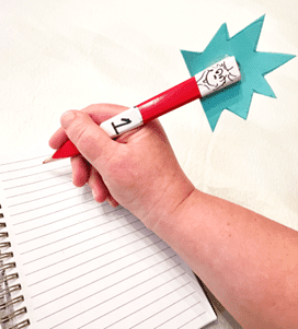 A hand holds a red pencil with a Thing 1 topper and a blue starburst.