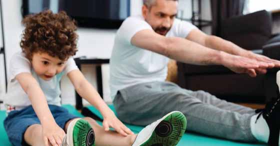 Man and child stretching on exercise mats