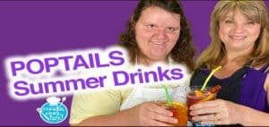 Two women hold glasses of colorful summer drinks.