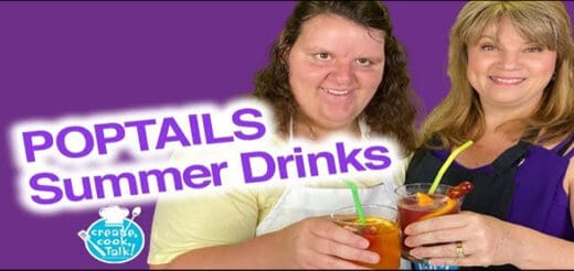 Two women hold glasses of colorful summer drinks.