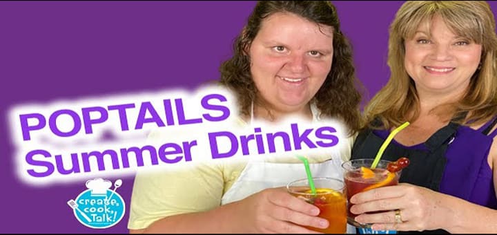 Two women hold glasses of colorful summer drinks.