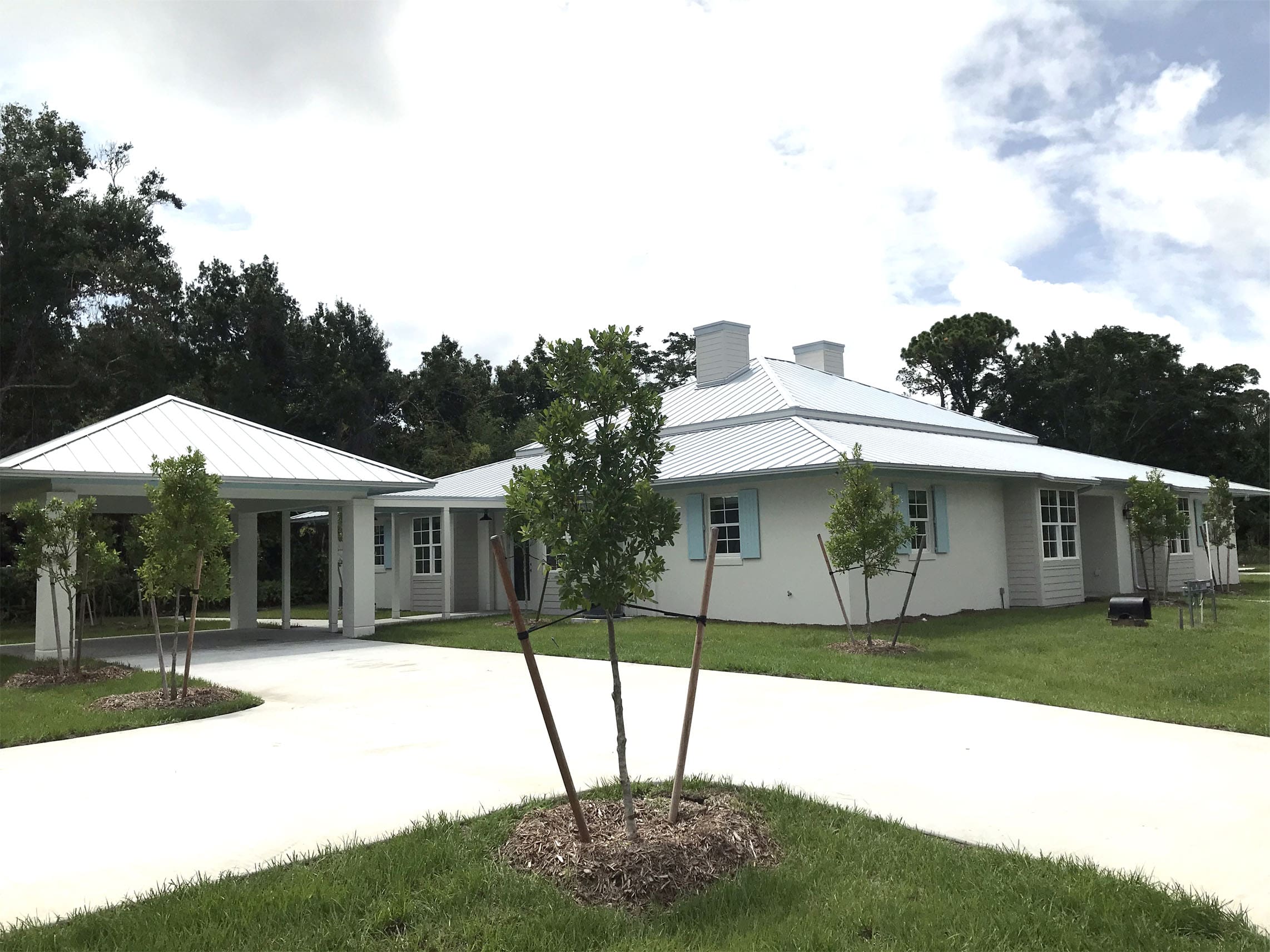 A white house with a covered carport attached.