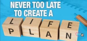 Four wooden blocks spell "LIFE PLAN" with the text "NEVER TOO LATE TO CREATE A" above.