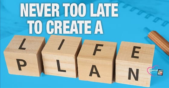 Four wooden blocks spell out "LIFE PLAN" with text above reading "NEVER TOO LATE TO CREATE A".