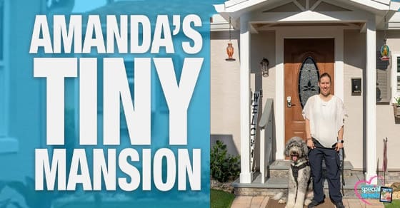 Amanda stands with a dog in front of her "Tiny Mansion.