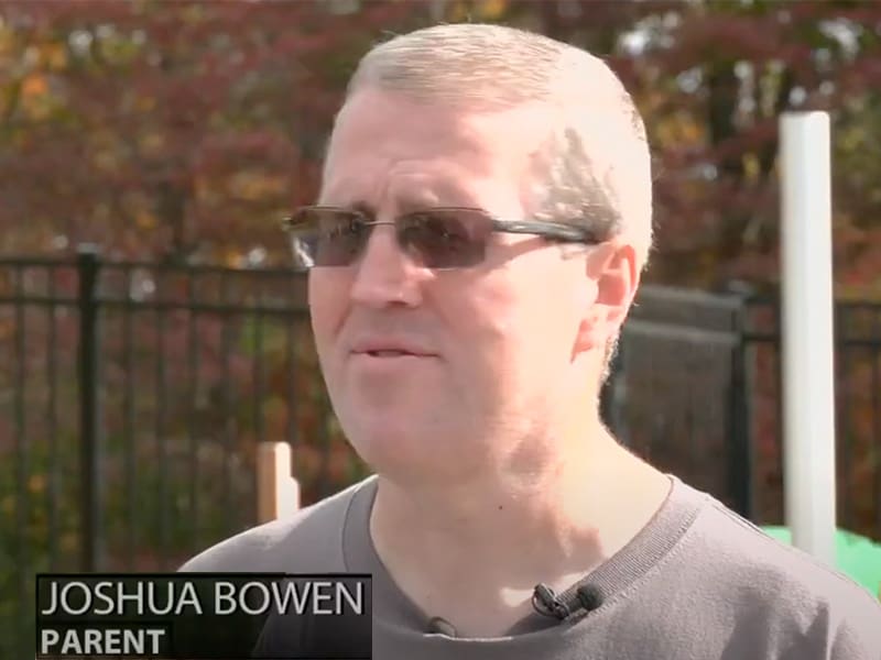 Joshua Bowen, parent, speaking outdoors.