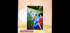 Children playing tug-of-war on a grassy hill.