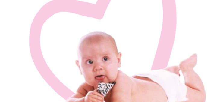 Baby lying on its stomach with a pacifier in its mouth and a pink heart behind it.