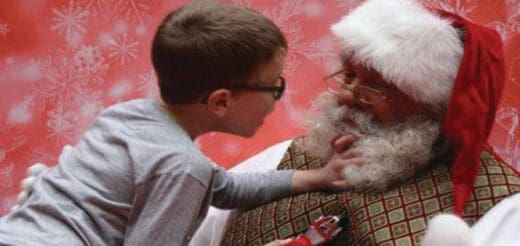 Boy in glasses talking to Santa Claus.