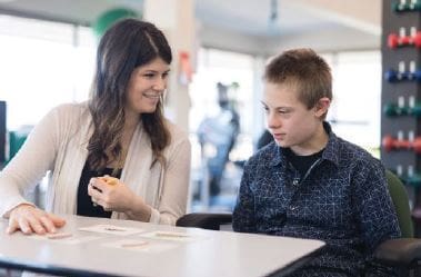 Woman and child sitting at a table with cards.