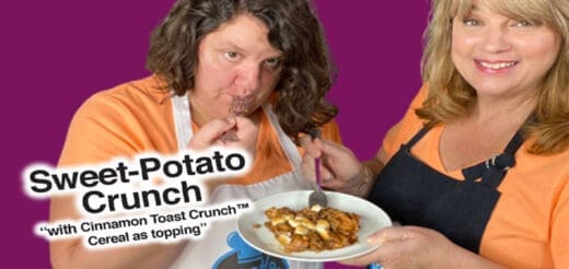 Two people in aprons holding a plate of sweet potato crunch topped with cereal.
