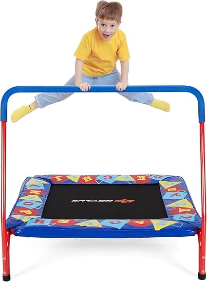 Toddler on a small trampoline with a safety bar.