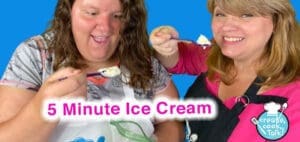 Two women smile while holding spoons with ice cream.