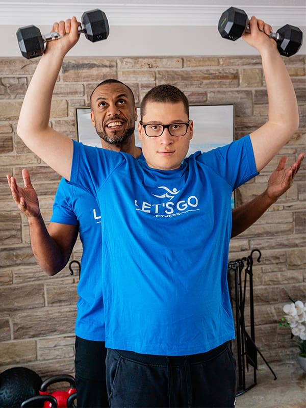 Keegan Johnson and his son, Dante, exercise with dumbbells.