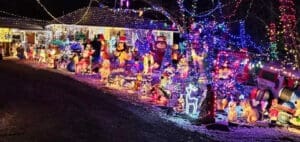 A house is decorated with numerous Christmas lights and inflatable figures.
