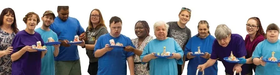 A group of people holding small white treats on plates.