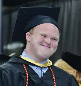 Nicholas McGee smiling while wearing a graduation cap and gown.